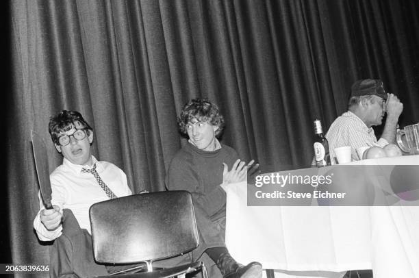 View of, from left, American magazine publisher & Rolling Stone co-founder Jann Wenner, holding a machete, an unidentified man, and journalist &...