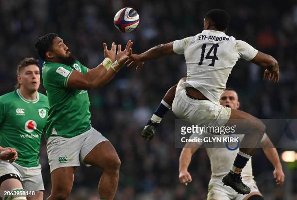 Ireland's centre Bundee Aki abd England's wing Immanuel Feyi-Waboso vie for the ball during the Six Nations international rugby union match between...