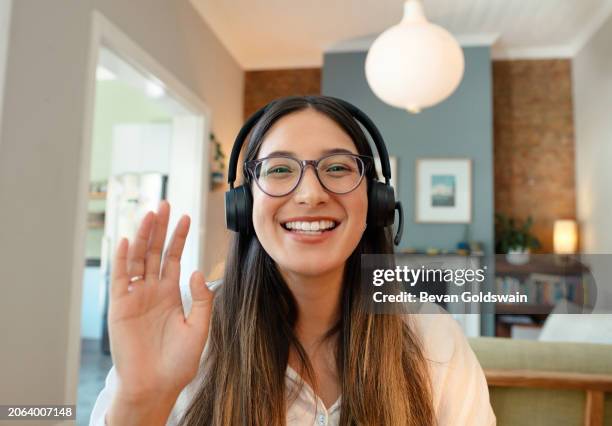 Ritratto Onda E Donna Felice In Videochiamata Con Auricolare A Casa Per Il Lavoro A Distanza O Il Telemarketing Viso Ciao E Libero Professionista In Webinar Riunione E Gesto Della Mano Di Benvenuto Per Il Saluto In Conferenza, Foto stock