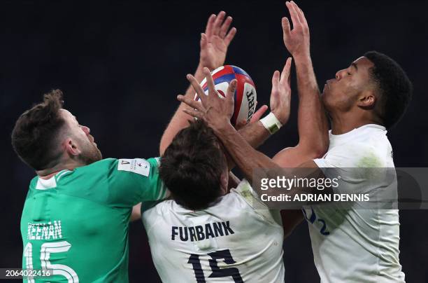 England's wing Immanuel Feyi-Waboso and England's full-back George Furbank vie for the ball with Ireland's full-back Hugo Keenan during the Six...