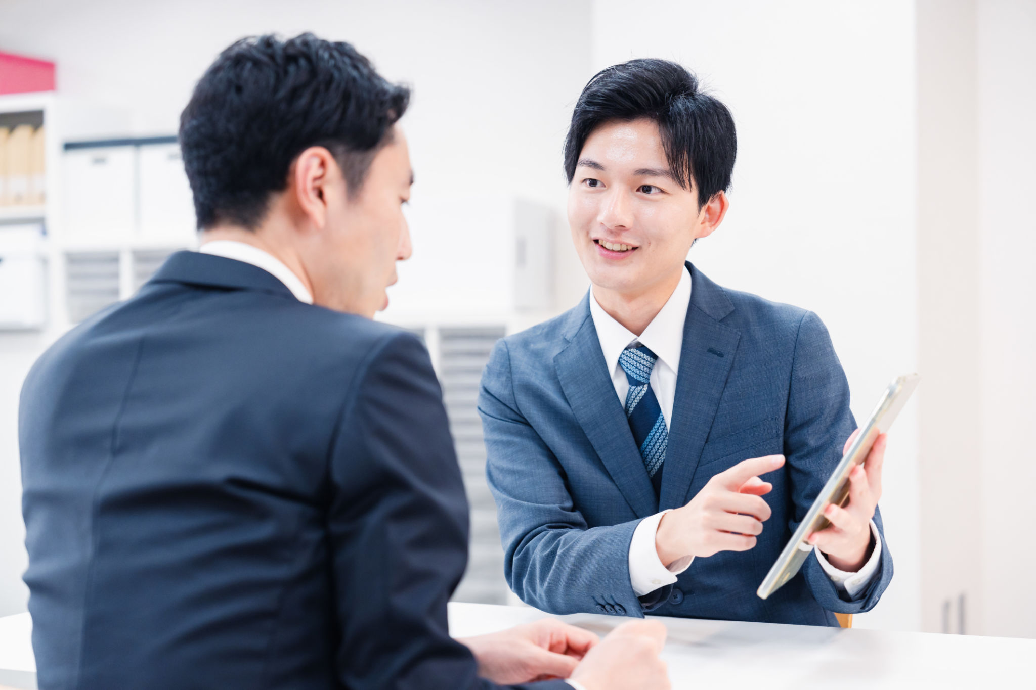 Businessman using a tablet terminal to explain at the counter. Businessman using a tablet terminal to explain at the counter.