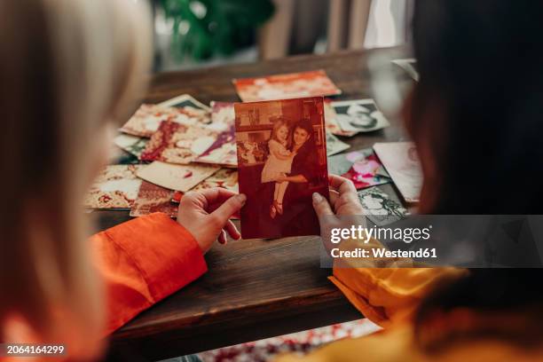 mother and daughter looking at family photos - tirage photographique photos et images de collection