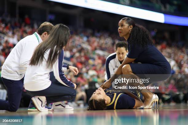Notre Dame Fighting Irish forward Kylee Watson is attended to by Notre Dame Fighting Irish head coach Niele Ivey and the training staff during the...