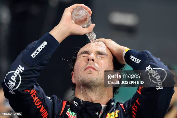 Second placed Red Bull Racing's Mexican driver Sergio Perez pours water on his face while waiting for the podium ceremony of the Saudi Arabian...