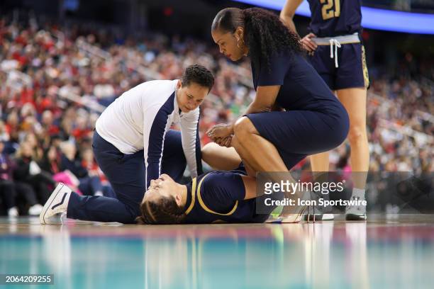 Notre Dame Fighting Irish head coach Niele Ivey comforts Notre Dame Fighting Irish forward Kylee Watson after her injury during the college...