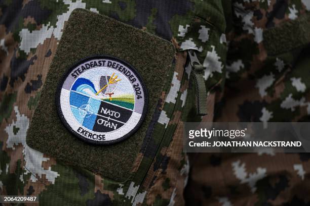 The badge of the NATO military exercise Steadfast Defender 2024 is pictured on the sleeve of Finnish Defence Minister Antti Hakkanen as he addresses...