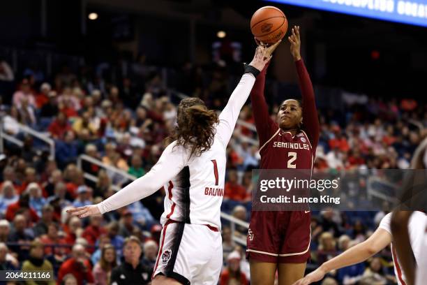 Alexis Tucker of the Florida State Seminoles puts up a shot against River Baldwin of the NC State Wolfpack during the first half of the game in the...