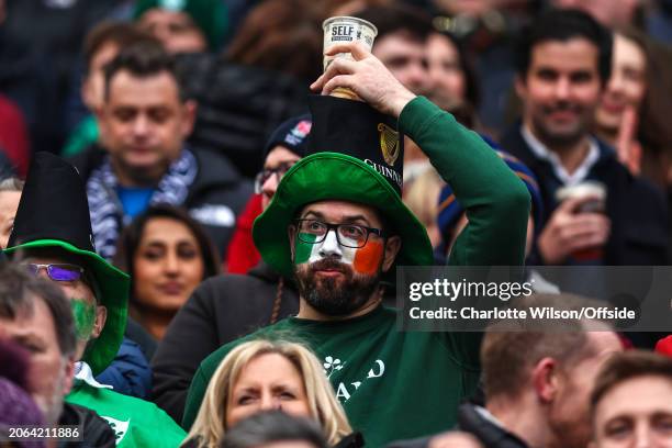 An Ireland fan balances an empty cup of Guinness on his head during the Guinness Six Nations 2024 match between England and Ireland at Twickenham...