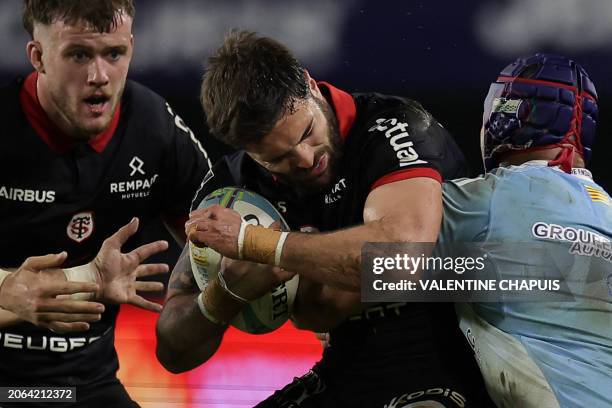 Toulouse's French wing Lucas Tauzin is tackled by Perpignan's Samoan hooker Seilala Lam during the French Top14 rugby union match between USA...