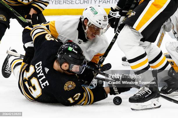 Ryan Graves of the Pittsburgh Penguins pins Charlie Coyle of the Boston Bruins down as they battle for a loose puck during the first period at TD...