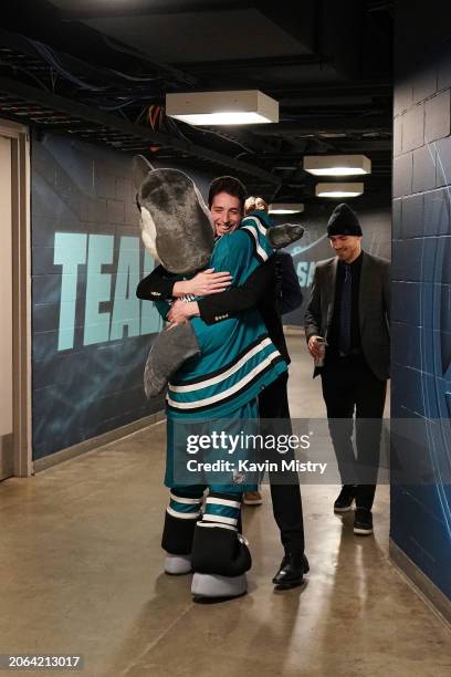 Devin Cooley of the San Jose Sharks arrives at the arena and is greeted by S.J. Sharkie before the game against the Ottawa Senators at SAP Center on...