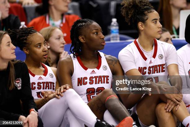 Aziaha James, Saniya Rivers and Madison Hayes of the NC State Wolfpack watch their teammates in action near the end of their game against the Florida...