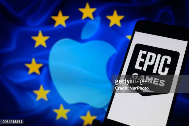 The Epic Games logo is being displayed on a smartphone with the Apple logo and the EU flag visible in the background in this photo illustration in...