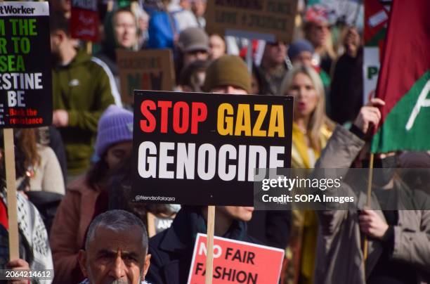 Protester holds a 'Stop Gaza genocide' placard during the demonstration. Thousands of people march to the US Embassy in solidarity with Palestine,...