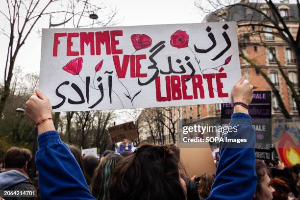 Woman seen with a placard that says "Female , Life and Freedom" during the International Women's Day demonstration. Thousands of protesters occupied...