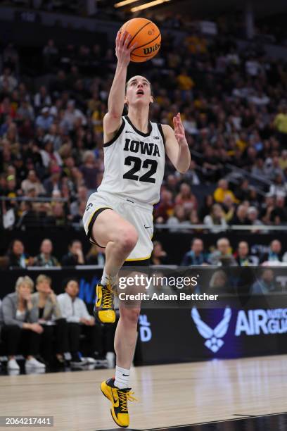 Caitlin Clark of the Iowa Hawkeyes drives for a layup against the Michigan Wolverines defends in the Semifinal Round of the Big Ten Tournament at...
