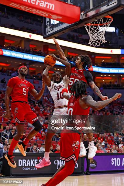 Boston College Eagles guard Prince Aligbe is fouled by Louisville Cardinals guard Skyy Clark as he goes up for with his shot during a mens college...