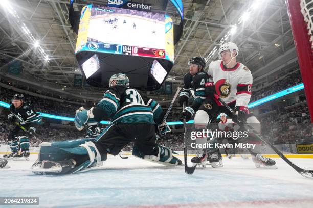 Marc-Edouard Vlasic and Magnus Chrona of the San Jose Sharks defend the net in the first period against Dominik Kubalik of the Ottawa Senators at SAP...