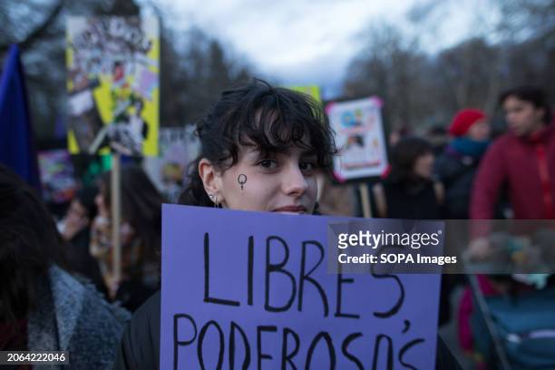 Girl with the Venus symbol on her face holds a placard that says 'Free and Powerful' during the demonstration. Every March 8th, International Women's...