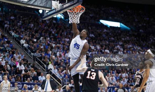 Fousseyni Traore of the Brigham Young Cougars slam dunks the ball over Connor Dow of the Oklahoma State Cowboy during the second half of their game...