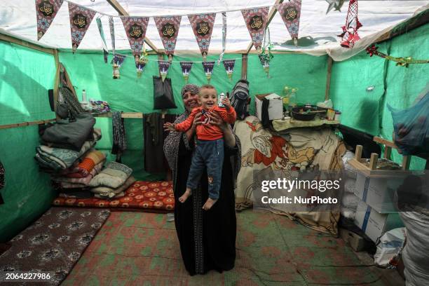 Displaced Palestinian woman is decorating her tent with Ramadan decorations in Deir al-Balah, in the central Gaza Strip, on March 9 amid the ongoing...