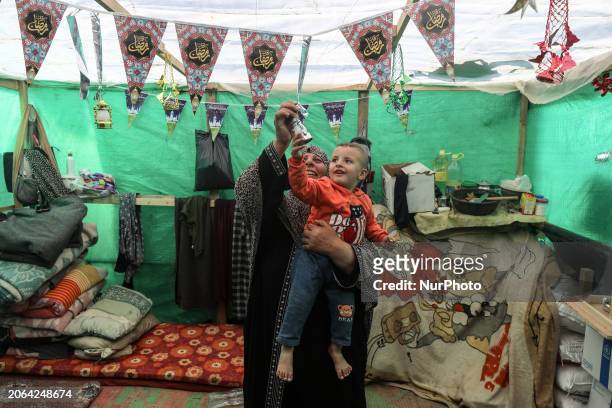 Displaced Palestinian woman is decorating her tent with Ramadan decorations in Deir al-Balah, in the central Gaza Strip, on March 9 amid the ongoing...