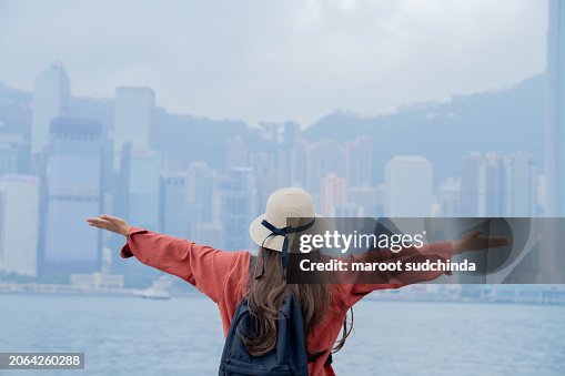 woman traveling in Hong Kong along with map and her camera, at Victoria harbour in Hong Kong.