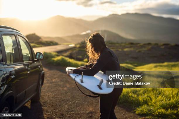 surfing after work at sunset. surfer girl gets ready to surf. - society islands stock pictures, royalty-free photos & images