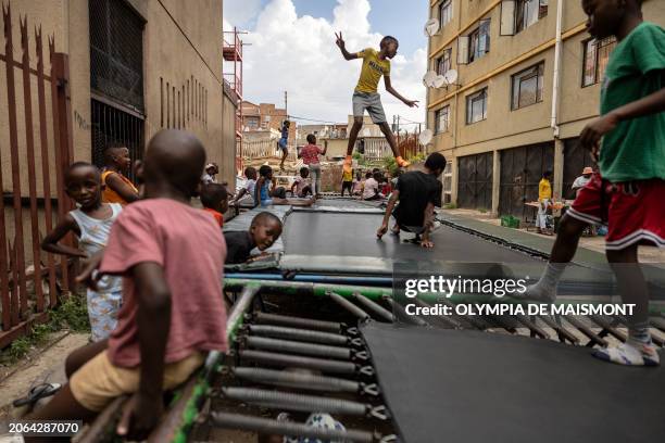 Children jump on a trampoline in Alexandra township near Johannesburg on March 9, 2024.