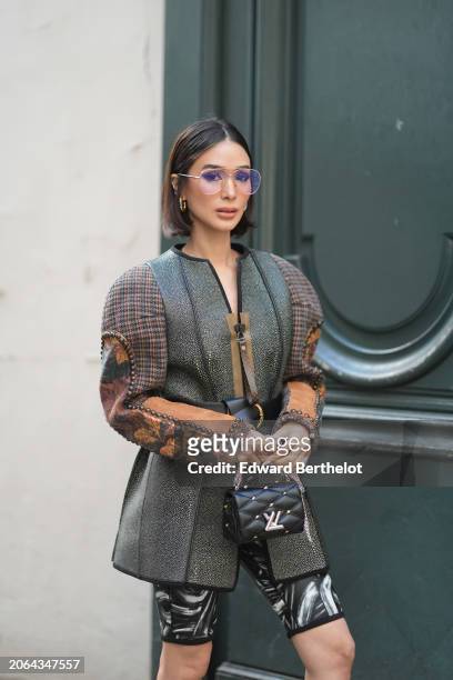 Heart Evangelista wears glasses, earrings, an oversized jacket , black and white shorts, a leather bag outside Louis Vuitton, during the Womenswear...