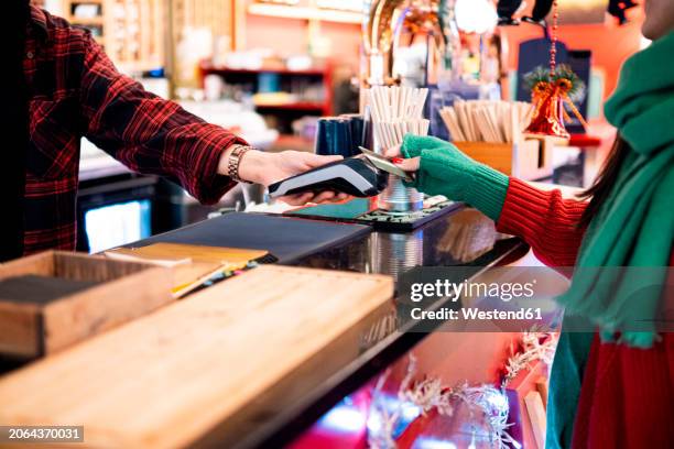 woman doing payment using credit card at cafe - fingerless glove stock pictures, royalty-free photos & images