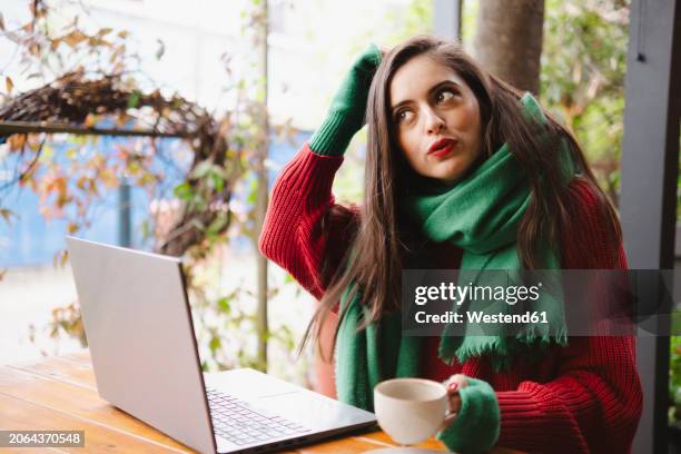 freelancer sitting near laptop with coffee cup at cafe - fingerless glove stock pictures, royalty-free photos & images