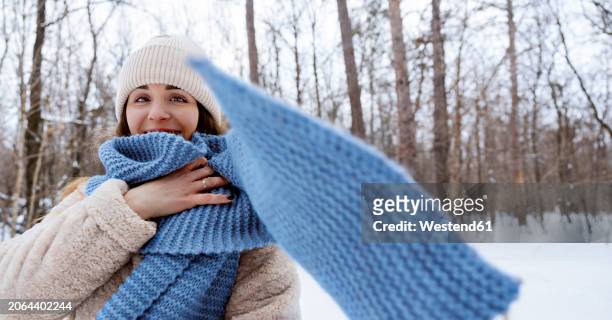 young woman wearing blue scarf in winter forest - woman flying scarf stock pictures, royalty-free photos & images