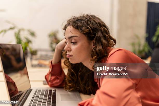 bored businesswoman looking at laptop on desk at office - laziness stock pictures, royalty-free photos & images