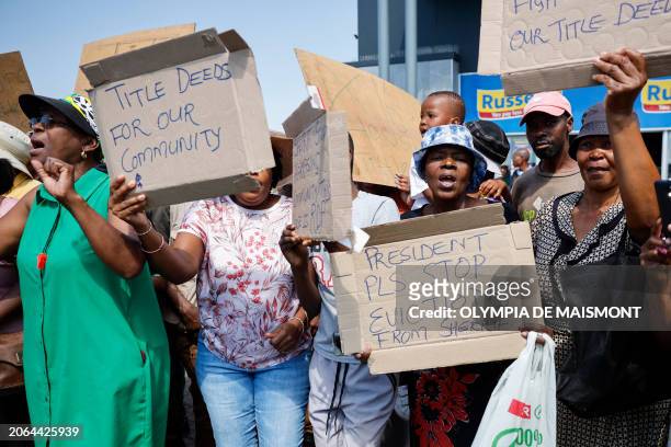 Supporters of African National Congress president and South African President Cyril Ramaphosa hold placards during a walkabout and a meet and greet...