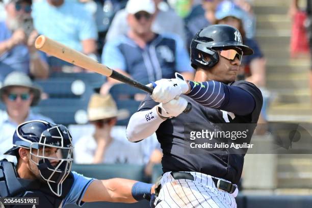 Juan Soto of the New York Yankees hits a single in the first inning against the Tampa Bay Rays during a 2024 Grapefruit League Spring Training game...