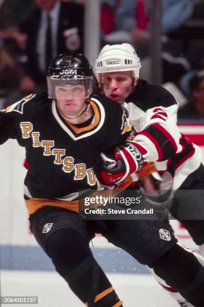 Pittsburgh Penguins forward, Jaromir Jagr, tries to escape the clutch from Devil's defensman, Viacheslav Fetisov, during the game against the NJ...