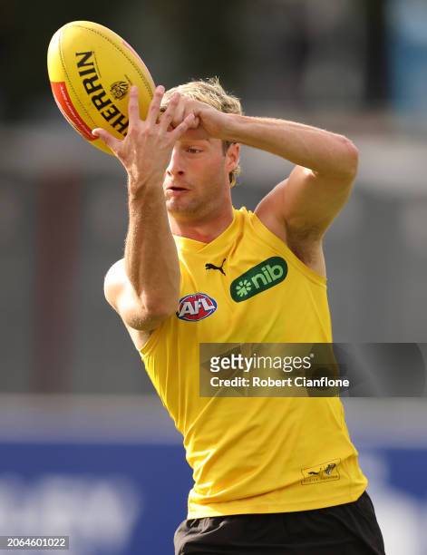 Tyler Sonsie of the Tigers handballs during a Richmond Tigers AFL Training Session & Media Opportunity at Punt Road Oval on March 07, 2024 in...