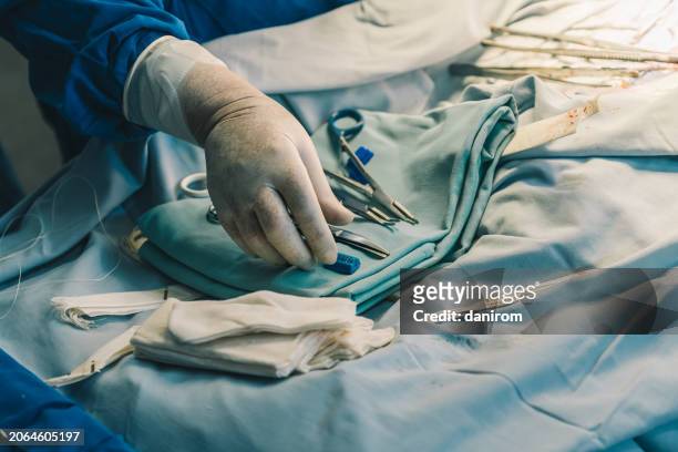 the surgical assistant grabs a surgical instrument in the operating room. - civil defence stock pictures, royalty-free photos & images