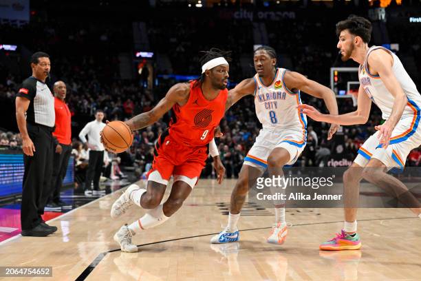 Jerami Grant of the Portland Trail Blazers dribbles against Jalen Williams and Chet Holmgren of the Oklahoma City Thunder at the Moda Center on March...