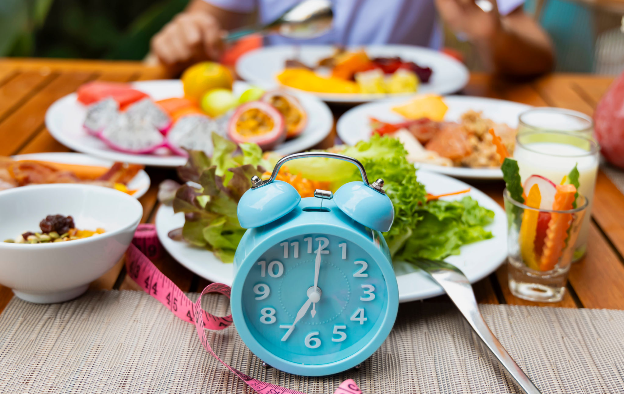 Blue alarm clock with IF (Intermittent Fasting) 16 and 8 diet rule and weight loss concept.-Diet plan concept Blue alarm clock with IF (Intermittent Fasting) 16 and 8 diet rule and weight loss concept.-Diet plan concept