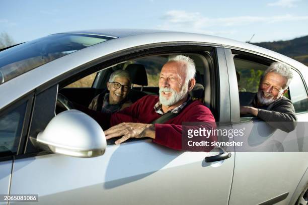 group of happy seniors having fun on a road trip in a car. - wonderlust stock-fotos und bilder