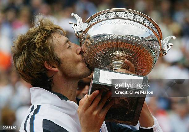 Juan Carlos Ferrero of Spain celebrates with the trophy after winning his mens final match against Martin Verkerk of the Netherlands during the 14th...