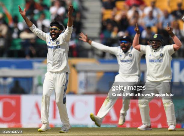 Ravindra Jadeja appeals successfully with Rohit Sharma and Sarfaraz Khan for the dismissal of Joe Root during day one of the 5th Test Match between...