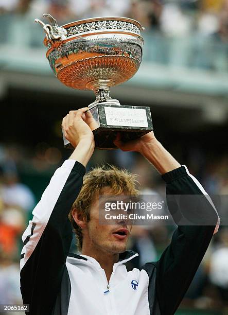Juan Carlos Ferrero of Spain celebrates with the trophy after winning his mens final match against Martin Verkerk of the Netherlands during the 14th...