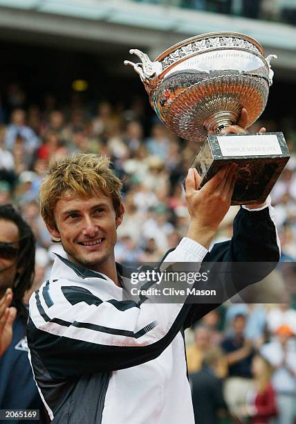 Juan Carlos Ferrero of Spain celebrates with the trophy after winning his mens final match against Martin Verkerk of the Netherlands during the 14th...