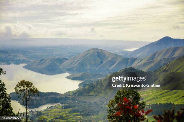 view of lake toba in the morning with the surrounding fog seen from tele hill. - lake toba sumatra stock pictures, royalty-free photos & images