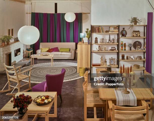 Interior view of a contemporary dining and living room containing a range of pine wood furniture, it includes a wooden dining table and four chairs,...