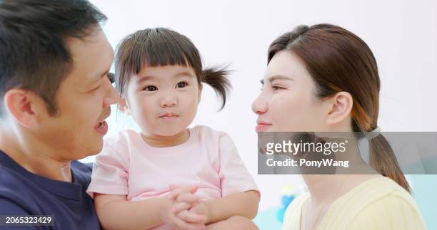 asian parent kiss little girl - accompanying stock pictures, royalty-free photos & images