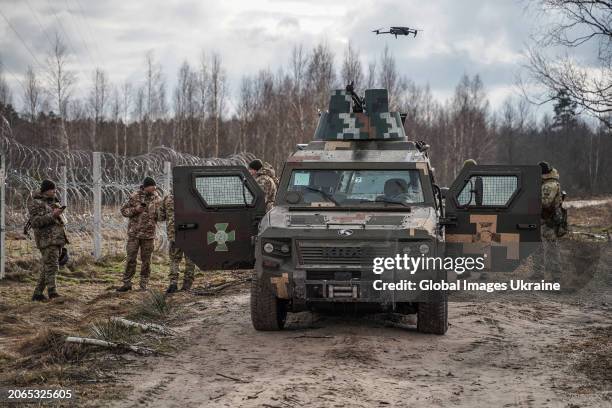 Ukrainian border guards stand near KrAZ Cobra Infantry mobility vehicle during patrolling of the border with Belarus on February 13, 2024 in Volyn...